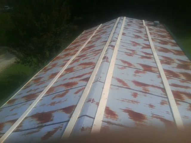 Rusted metal roof panels with new wood purlins before replacement — Storm Damage Roof Repair in Merrimack by Roofing Brothers