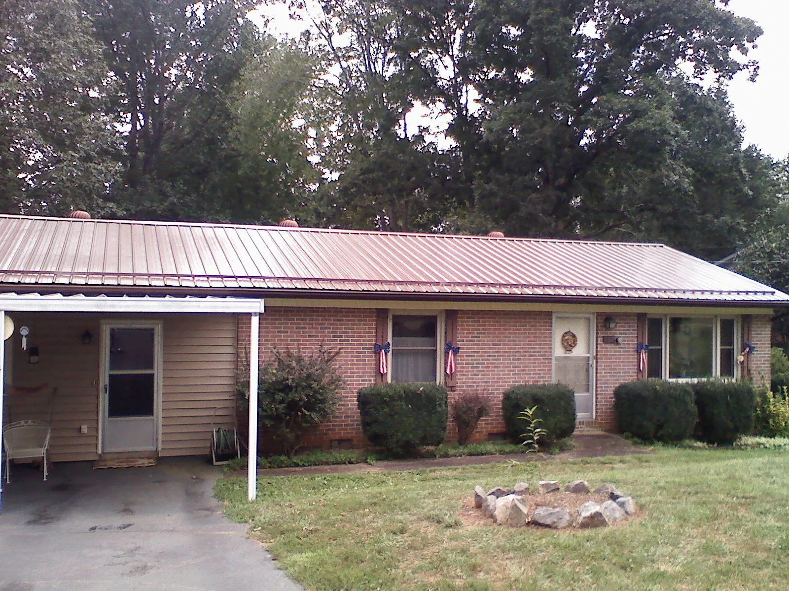 Bronze metal roof and carport on a brick ranch home — Roof Repair work by our crew in Merrimack